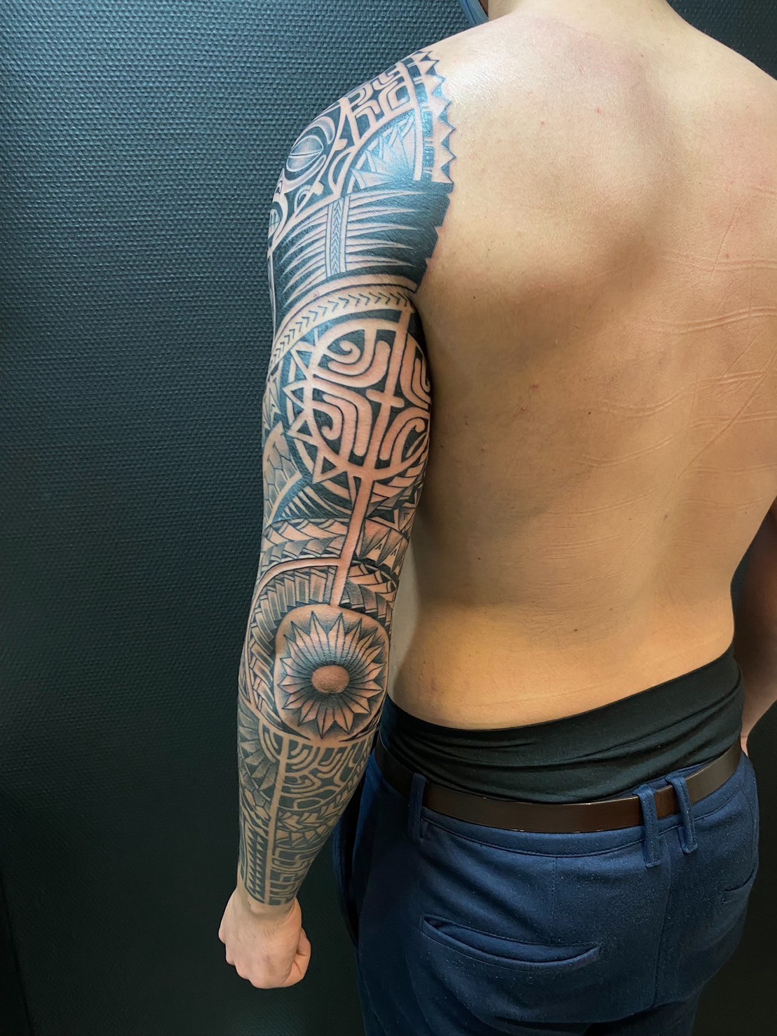 Polynesian style half-sleeve tattoo on man's arm
