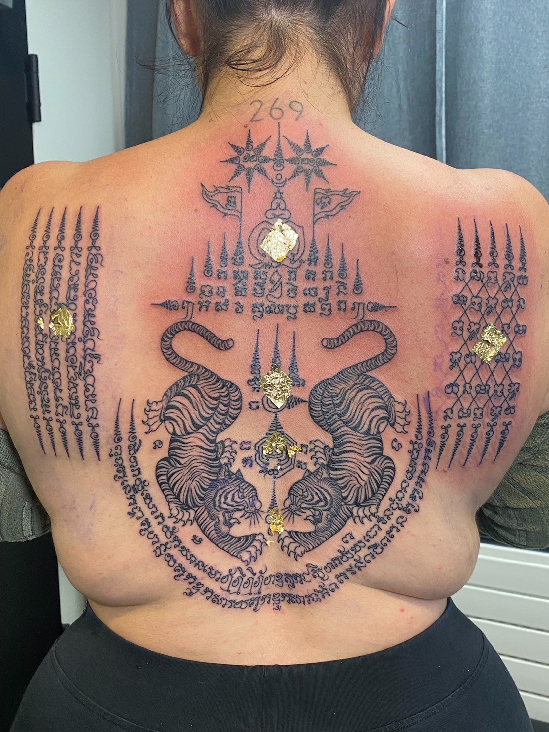 Sak Yant back tattoo with gold leaf