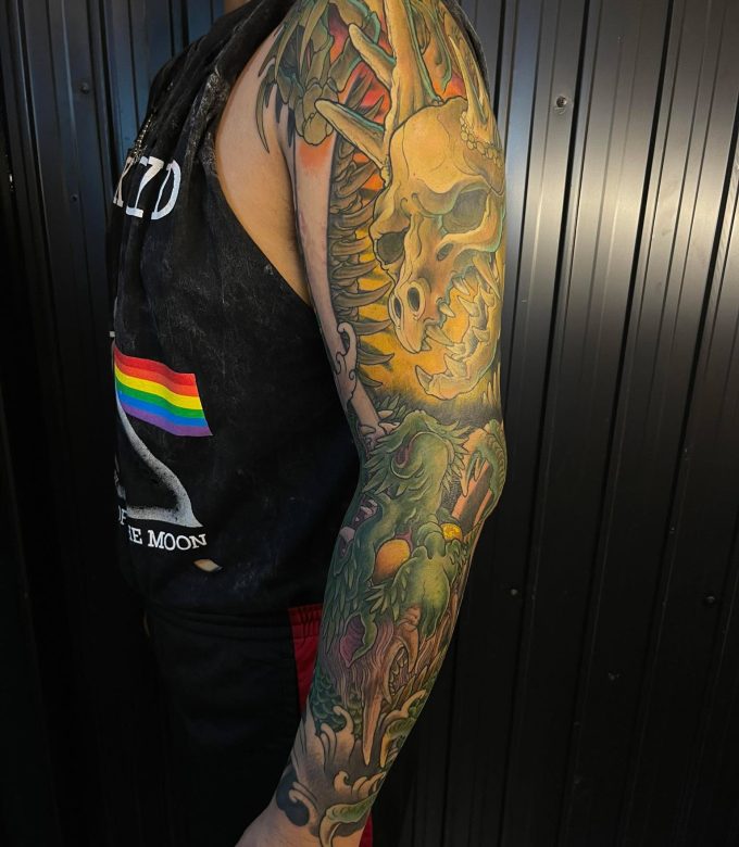 Japanese dragon and skull tattoo sleeve in neo-japanese style with green and yellow tones, custom full sleeve tattoo design