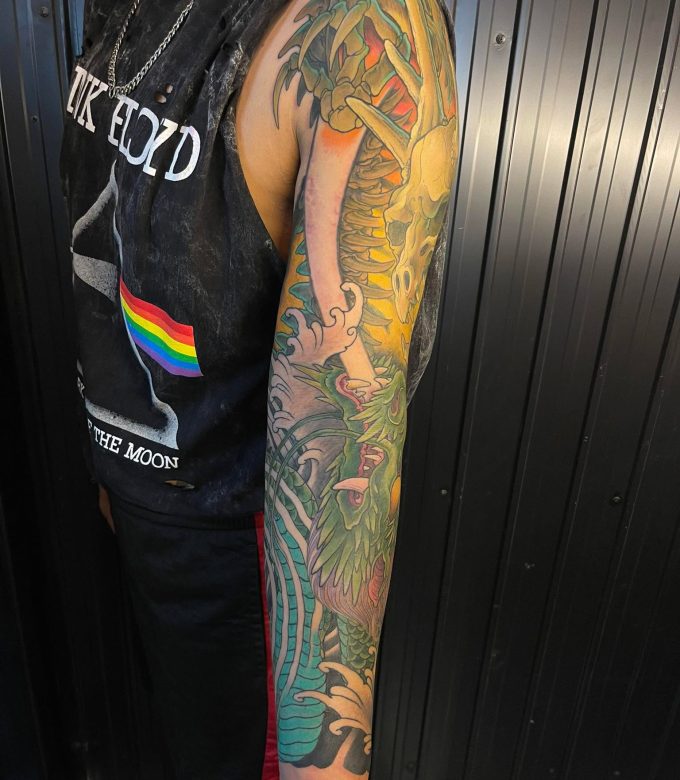 Green Japanese dragon full sleeve tattoo side view with detailed scales and flowing neo-japanese design, custom tattoo Pattaya