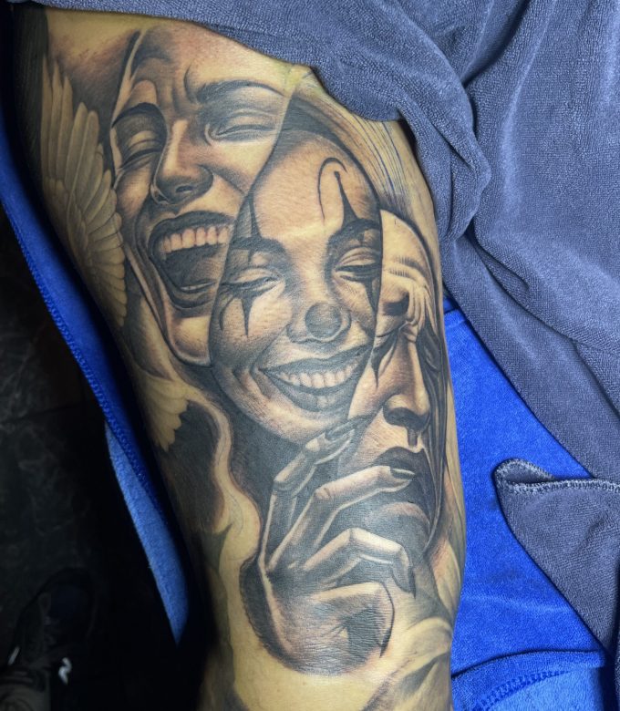 Realistic black and grey portrait tattoo on arm featuring expressive smiling faces, high-detail realism tattoo by Dragonking Tattoo Pattaya
