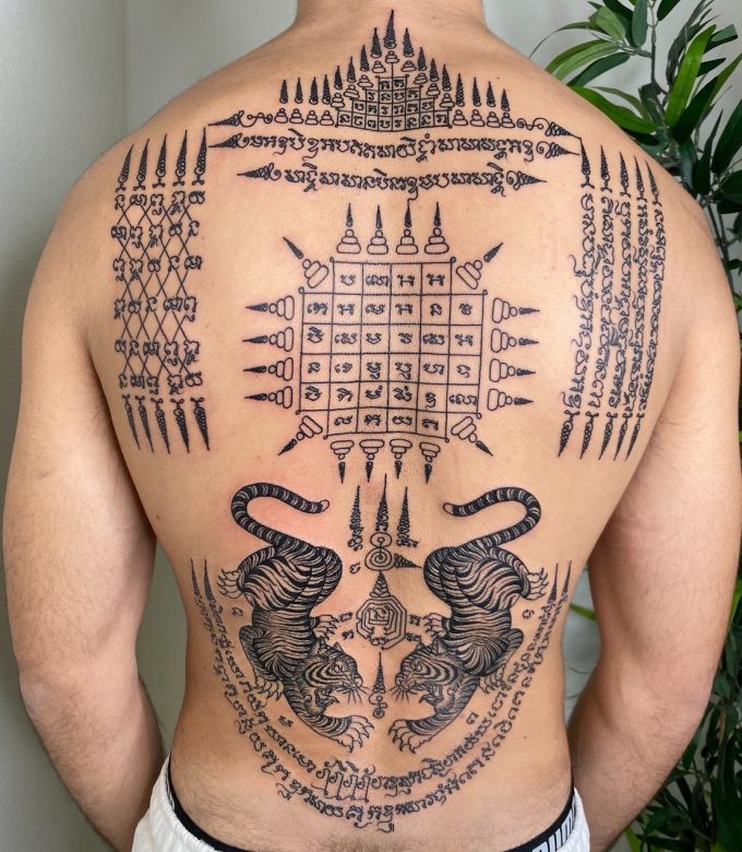 Traditional Sak Yant full back tattoo with twin tiger and sacred yantra symbols, bamboo hand-poked tattoo by Dragonking Tattoo Pattaya