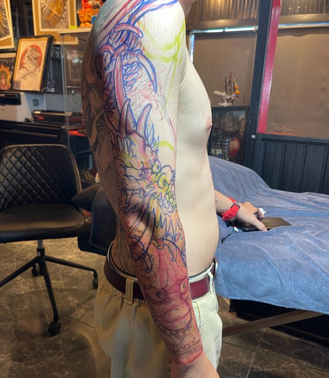 Freehand dragon and Hannya mask full sleeve tattoo in progress, custom Japanese tattoo designed directly on the body by Dragonking Tattoo Pattaya